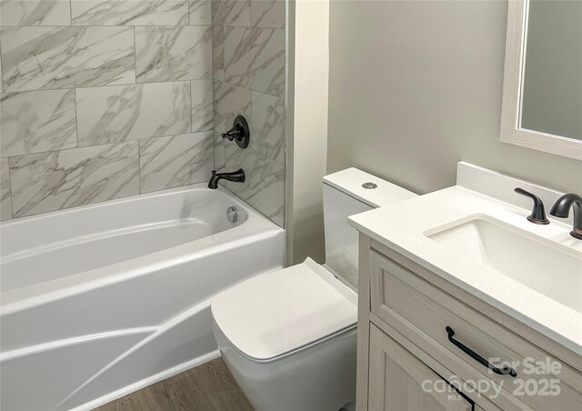 full bath with toilet, vanity, shower / washtub combination, and wood finished floors