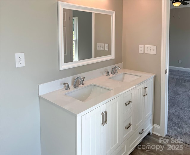bathroom featuring double vanity, ceiling fan, and baseboards