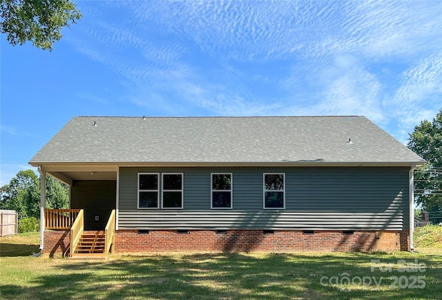 rear view of house with crawl space and a yard