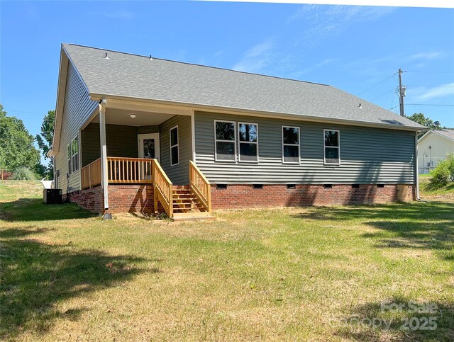 rear view of house with crawl space, a yard, central AC unit, and a shingled roof