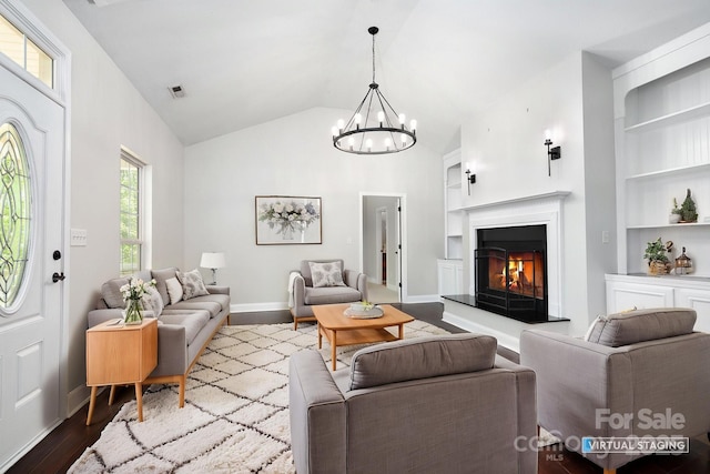 62 Mackenzie Way, Swannanoa, NC 28778 - living area featuring an inviting chandelier, lofted ceiling, baseboards, dark wood-type flooring, and built in shelves