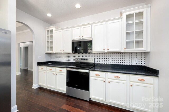 62 Mackenzie Way, Swannanoa, NC 28778 - kitchen featuring white cabinets, appliances with stainless steel finishes, arched walkways, backsplash, and glass insert cabinets