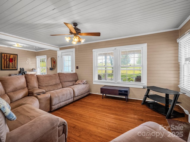 living area featuring wood ceiling, a ceiling fan, crown molding, wood walls, and wood finished floors