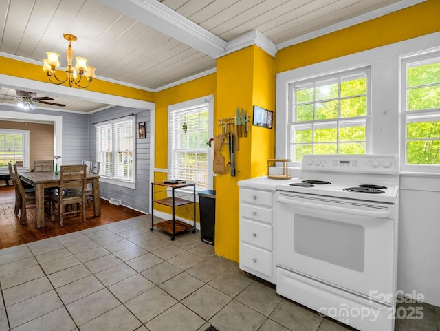 kitchen with crown molding, white range with electric cooktop, plenty of natural light, ceiling fan with notable chandelier, and light tile patterned floors