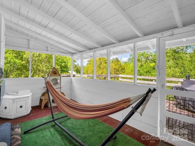 sunroom / solarium featuring a healthy amount of sunlight and beam ceiling
