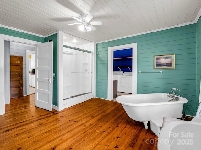 full bathroom with washer and dryer, ceiling fan, hardwood / wood-style floors, ornamental molding, and a stall shower