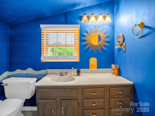 half bathroom with vanity, lofted ceiling, and toilet