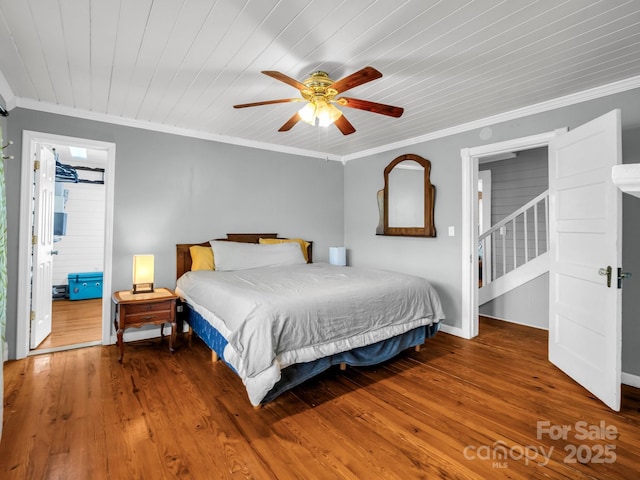 bedroom featuring crown molding, wood finished floors, baseboards, wooden ceiling, and a ceiling fan