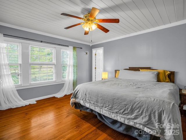 bedroom with ornamental molding, hardwood / wood-style floors, baseboards, ceiling fan, and wooden ceiling