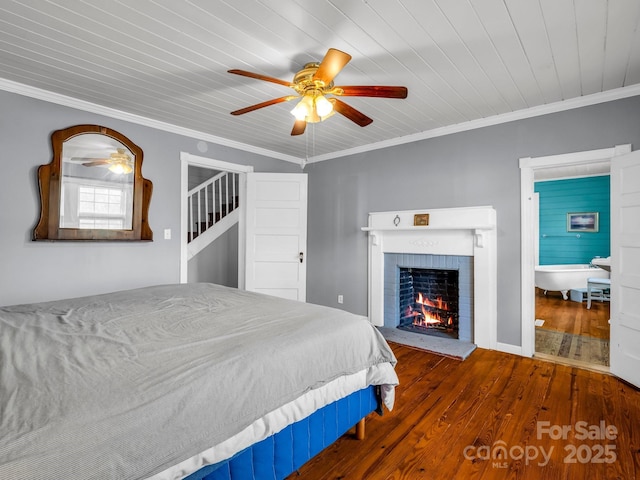 bedroom with crown molding, a brick fireplace, wood finished floors, ceiling fan, and wooden ceiling