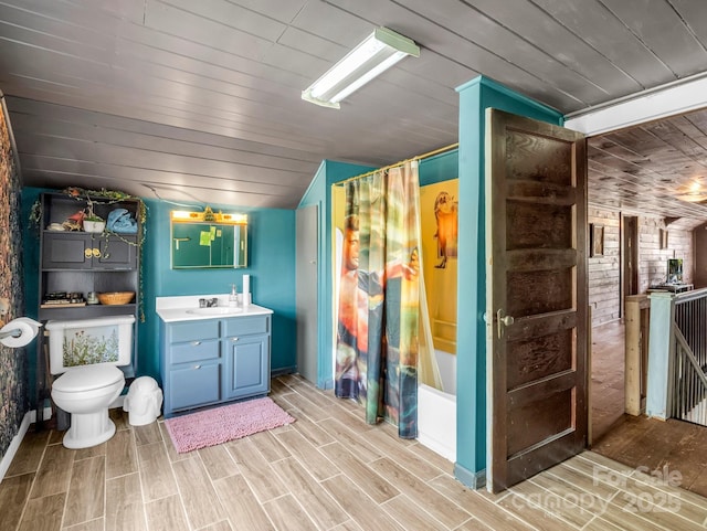 bathroom featuring vanity, toilet, brick wall, wooden ceiling, and wood finished floors