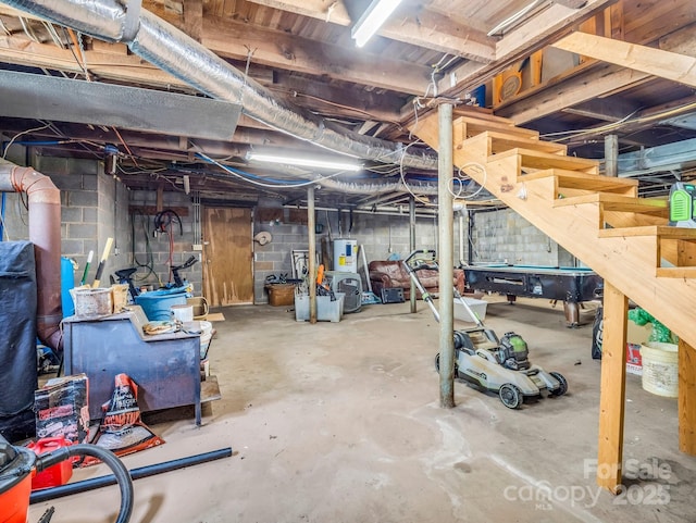 unfinished basement with concrete block wall and electric water heater