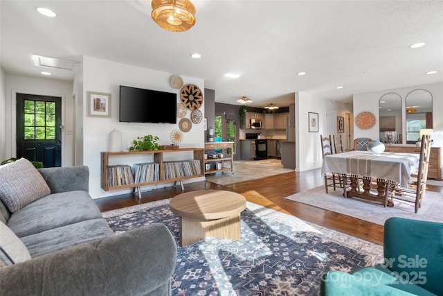 living room featuring attic access, recessed lighting, and wood finished floors