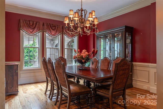 135 Sumter Dr, Mooresville, NC 28117 - dining area with a wainscoted wall, wood finished floors, a notable chandelier, and a healthy amount of sunlight