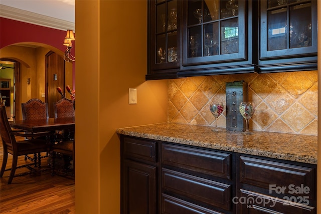 135 Sumter Dr, Mooresville, NC 28117 - bar featuring crown molding, arched walkways, decorative backsplash, wood finished floors, and a bar
