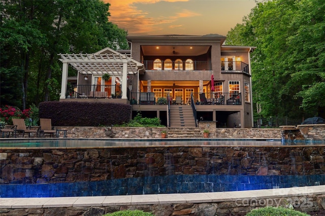135 Sumter Dr, Mooresville, NC 28117 - back of house at dusk with a pergola, french doors, a balcony, and stairs