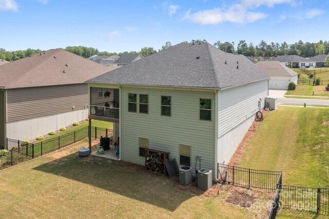 7620 Porrera St, Charlotte, NC 28214 - back of house with a fenced backyard, roof with shingles, a yard, and cooling unit
