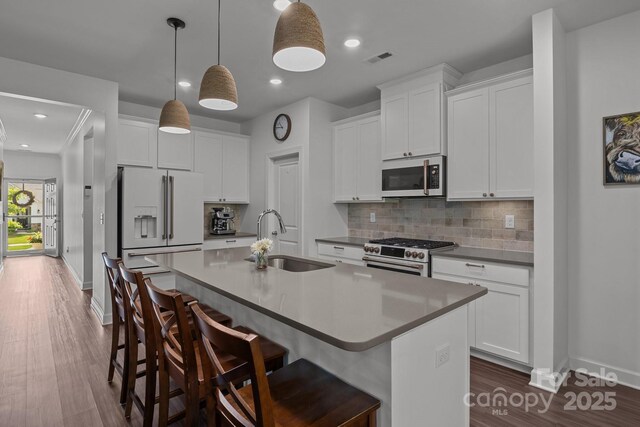 7620 Porrera St, Charlotte, NC 28214 - kitchen with visible vents, appliances with stainless steel finishes, a center island with sink, a sink, and baseboards