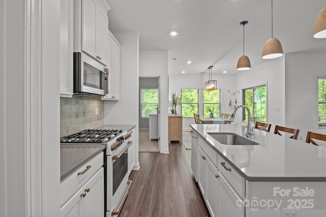 7620 Porrera St, Charlotte, NC 28214 - kitchen featuring appliances with stainless steel finishes, a sink, recessed lighting, dark wood-type flooring, and a center island with sink