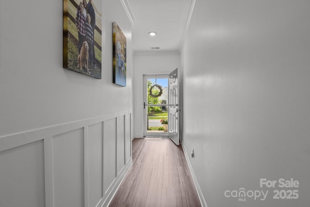7620 Porrera St, Charlotte, NC 28214 - hall with baseboards, ornamental molding, wood finished floors, and visible vents