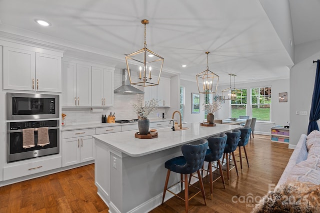 7730 Burning Ridge Dr, Stanley, NC 28164 - kitchen featuring stainless steel oven, wall chimney range hood, built in microwave, a sink, and a chandelier