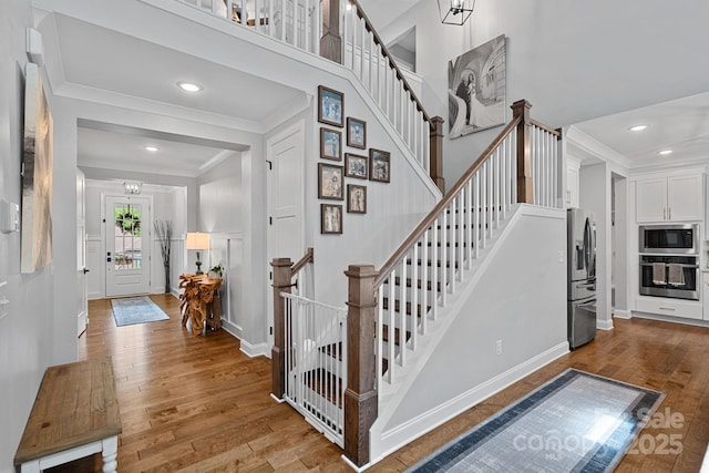 7730 Burning Ridge Dr, Stanley, NC 28164 - foyer entrance featuring crown molding, a high ceiling, wood finished floors, stairway, and baseboards