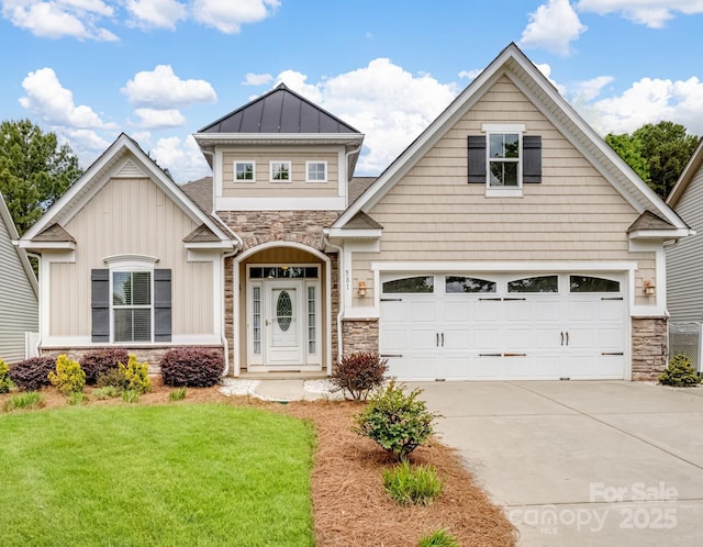 craftsman-style house featuring a garage, a front lawn, stone siding, a standing seam roof, and driveway
