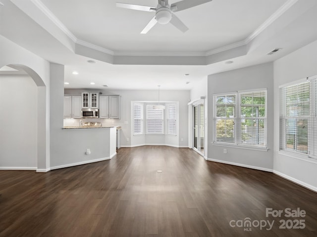 unfurnished living room with crown molding, a wealth of natural light, and visible vents
