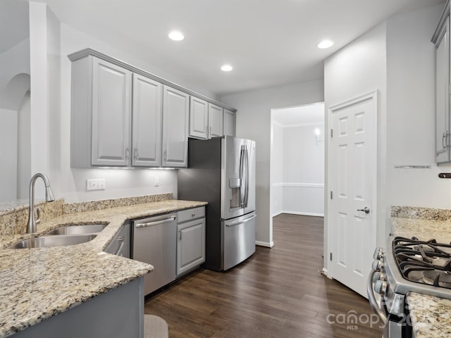 kitchen featuring a sink, gray cabinetry, light stone countertops, and stainless steel appliances