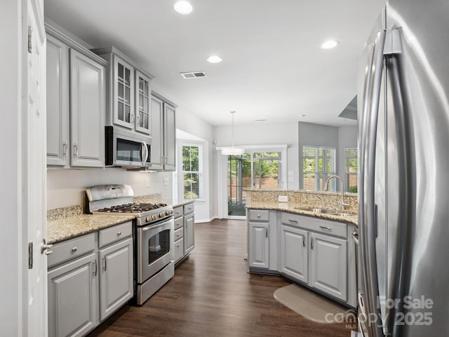 kitchen featuring gray cabinets, stainless steel appliances, and visible vents