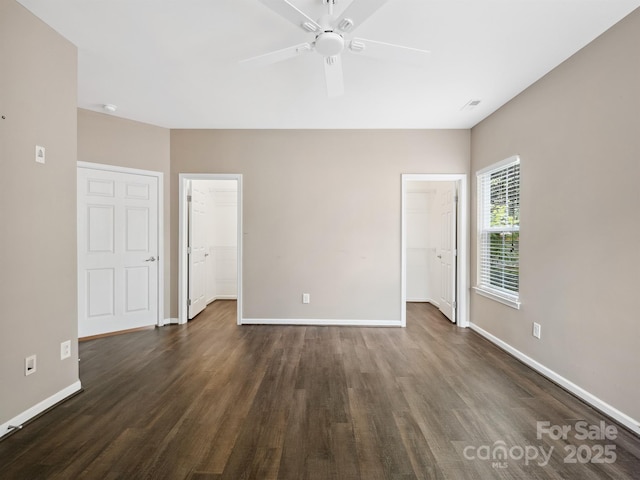 unfurnished room featuring baseboards, dark wood-style floors, and ceiling fan