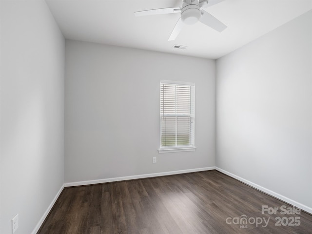 spare room featuring baseboards, a ceiling fan, wood finished floors, and visible vents