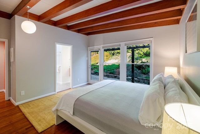 bedroom with baseboards, ensuite bath, beam ceiling, and wood finished floors