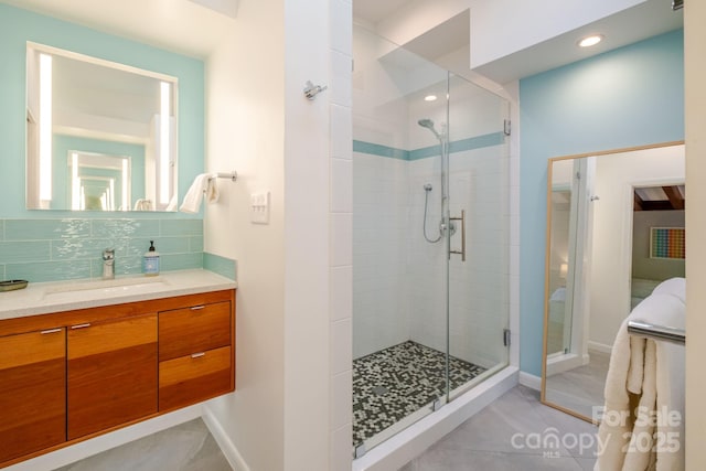 bathroom with backsplash, tile patterned flooring, a stall shower, vanity, and baseboards
