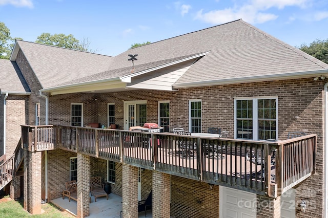 back of house with brick siding, a shingled roof, and a patio area