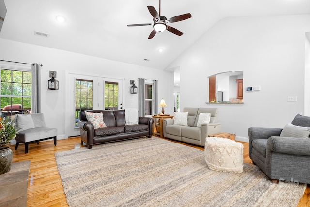 living room with ceiling fan, visible vents, high vaulted ceiling, baseboards, and light wood-style floors