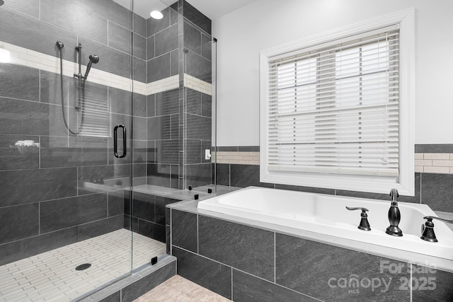 bathroom with a shower stall and a garden tub