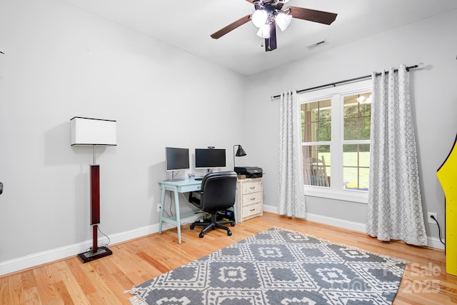 office featuring a ceiling fan, baseboards, visible vents, and wood finished floors