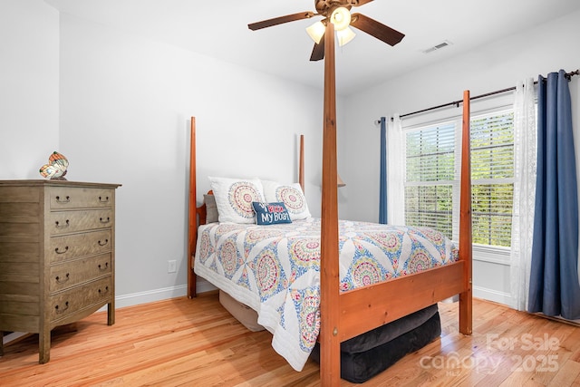 bedroom featuring visible vents, a ceiling fan, baseboards, and light wood-type flooring