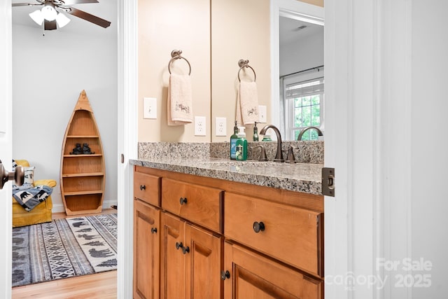 bathroom featuring vanity, ceiling fan, wood finished floors, and visible vents