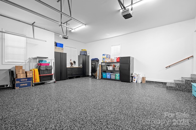 garage with freestanding refrigerator and a garage door opener