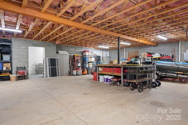 garage with concrete block wall and a workshop area