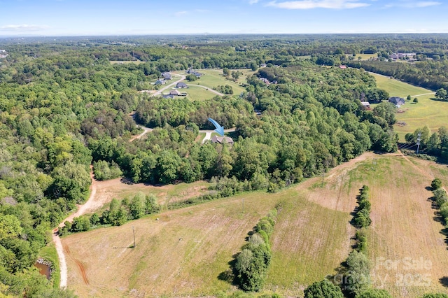 birds eye view of property with a rural view and a wooded view
