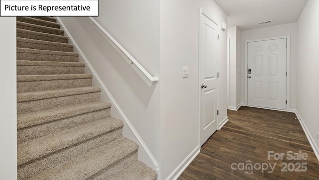 stairs featuring visible vents, wood finished floors, and baseboards