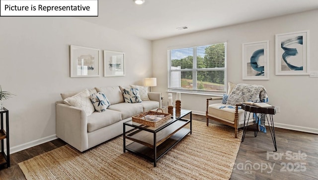 living area featuring visible vents, wood finished floors, and baseboards
