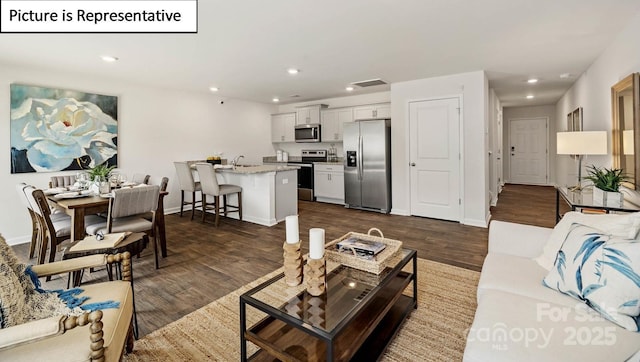 living area with dark wood-style floors, recessed lighting, visible vents, and baseboards