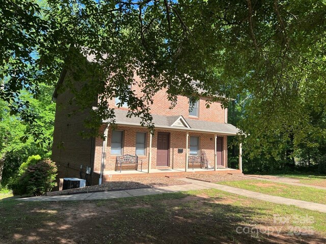 116 Fairview St, Shelby, NC 28152 - view of front of property with brick siding, covered porch, central AC, and a front lawn