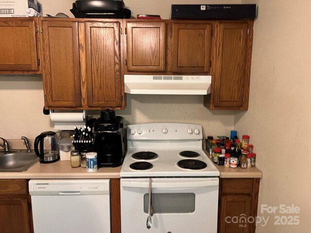 116 Fairview St, Shelby, NC 28152 - kitchen featuring white appliances, under cabinet range hood, a sink, light countertops, and brown cabinetry