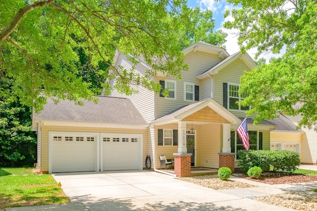 view of front of home featuring a porch, a garage, driveway, and roof with shingles