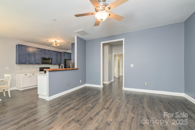 kitchen with black microwave, stainless steel refrigerator with ice dispenser, range, baseboards, and dark wood-style flooring